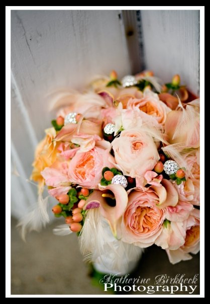 This beautiful bridal bouquet has lush roses surrounded by berries and a